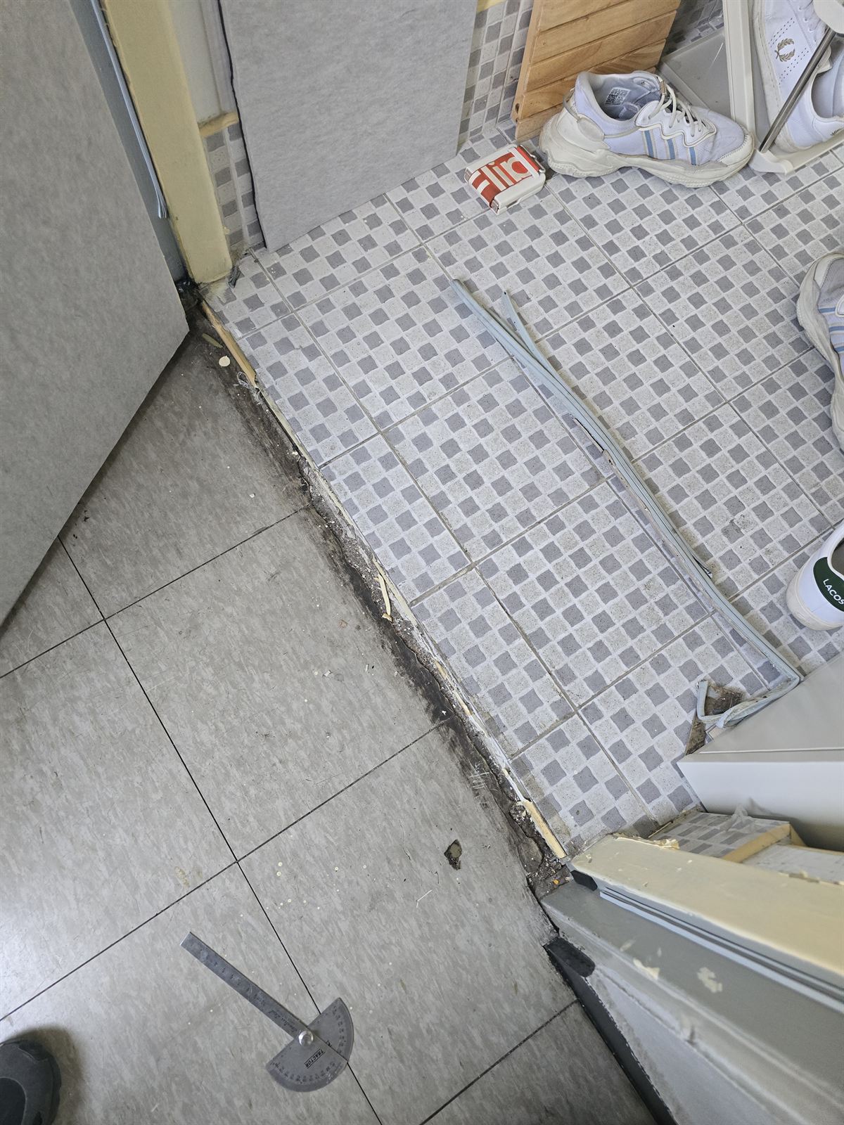 현관문턱 수리 – 마감이 깨져 충전재가 드러난 노후 현관 문턱